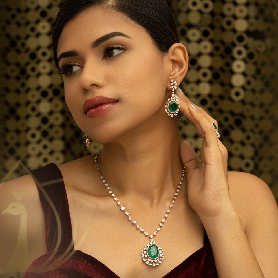 A female model is wearing a diamond necklace with a beautiful pendant and earrings with a emerald stones.
