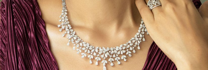 Close up shot of a woman wearing diamond necklace with matching earring