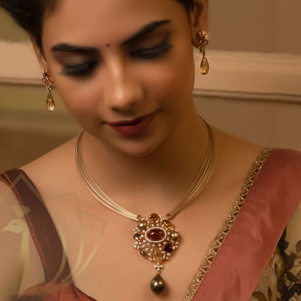 A woman is wearing a golden necklace with diamond pendant along with a beautiful earrings, posing with a traditional saree wear.