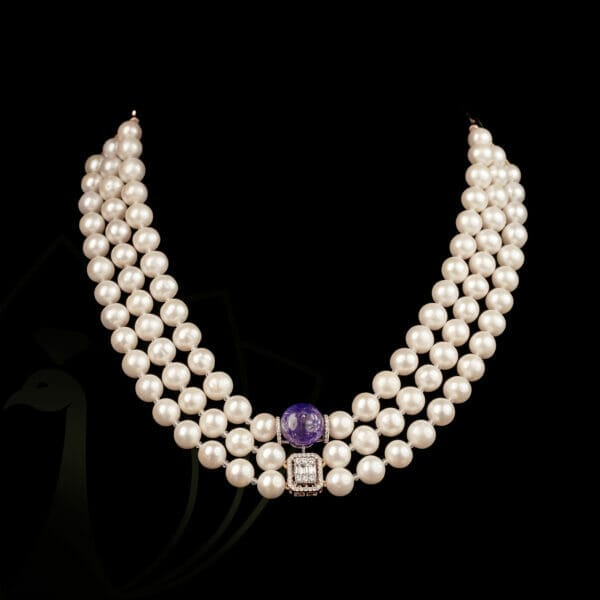 A pretty pearl necklace with purple gemstone and solitaire diamond.