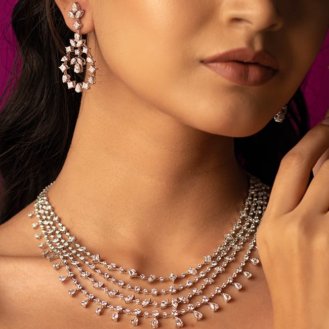 Close-up shot of a bride wearing a bridal diamond layered necklace and diamond earrings, the Sangeeth collection from Khwaahish.