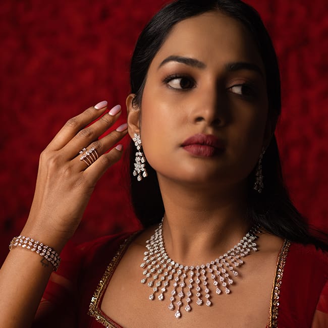 A bride poses with a majestic bridal diamond necklace, diamond bangle, diamond ring, and diamond earrings, the engagement collection from Khwaahish.